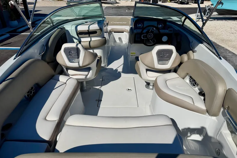 Slide: The Image of 2023 Crownline Eclipse E235 XS boat interior with beige seating and modern dashboard. - 26
