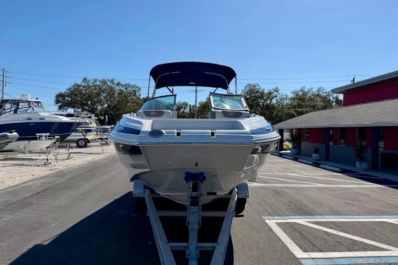 Slide: The Image of 2023 Crownline Eclipse E235 XS boat on trailer in sunny outdoor setting. - 3