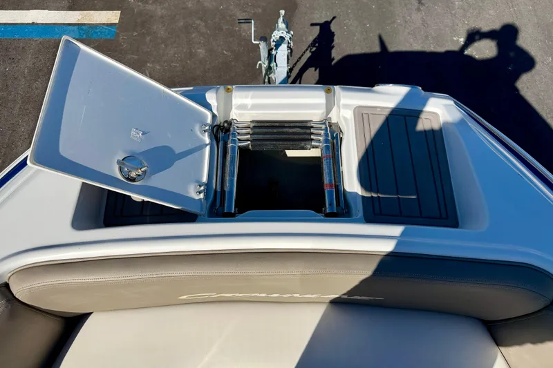 Slide: The Image of 2023 Crownline Eclipse E235 XS boat with open storage compartment and ladder. - 34