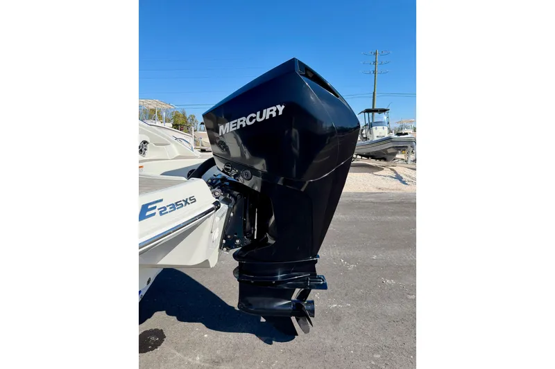 Slide: The Image of 2023 Crownline Eclipse E235 XS with Mercury outboard motor, parked on asphalt. - 36