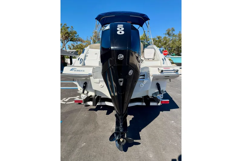Slide: The Image of 2023 Crownline Eclipse E235 XS boat with powerful outboard motor in a parking lot. - 37