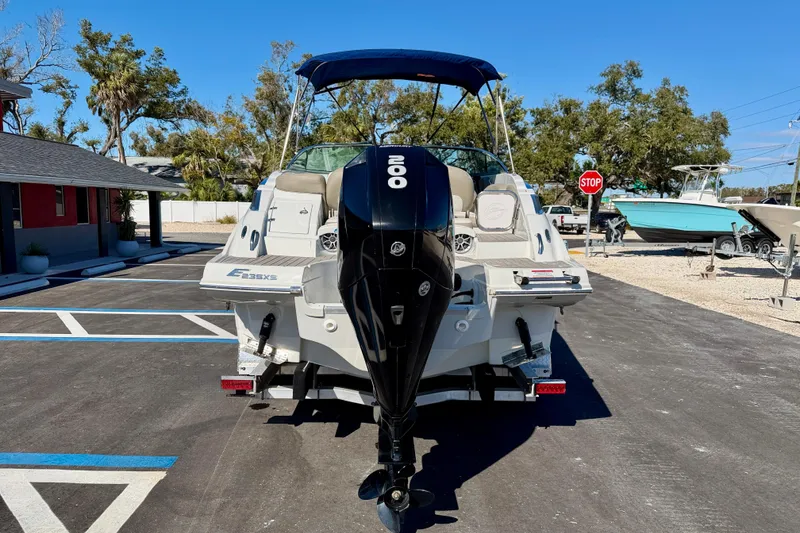Slide: The Image of 2023 Crownline Eclipse E235 XS boat with outboard motor in a parking lot. - 6