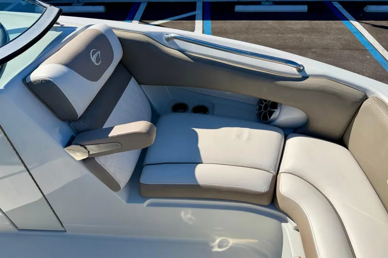 Slide: The Image of 2023 Crownline Eclipse E235 XS boat interior with cushioned seating and speaker. - 9