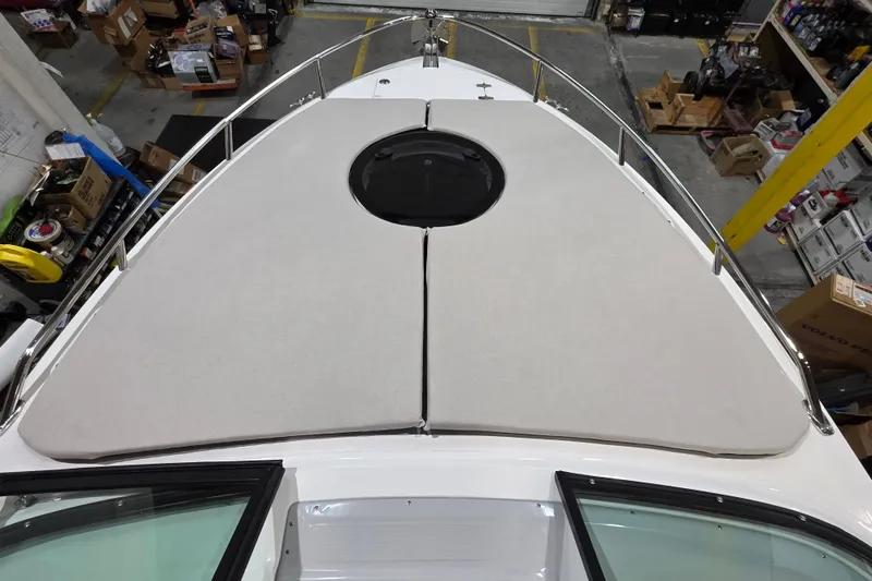 Slide: The Image of 2026 Regal LS4C boat with cushioned bow deck in a warehouse setting. - 16