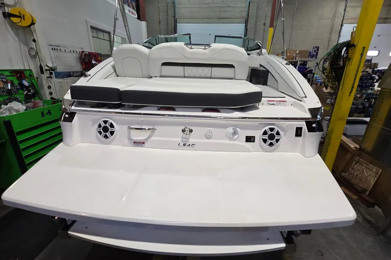 Slide: The Image of 2026 Regal LS4C boat rear view in a workshop, featuring speakers and seating. - 2