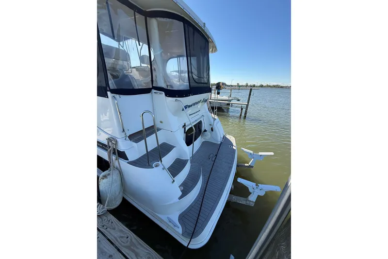 Slide: The Image of 2002 Silverton 39 Motor Yacht docked by the water on a sunny day. - 2