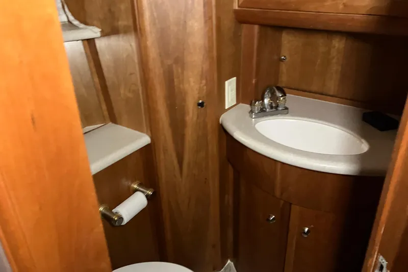 Slide: The Image of 2002 Silverton 39 Motor Yacht bathroom with wooden cabinetry and compact sink. - 38