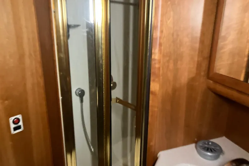 Slide: The Image of 2002 Silverton 39 Motor Yacht bathroom with wooden cabinetry and glass shower door. - 42