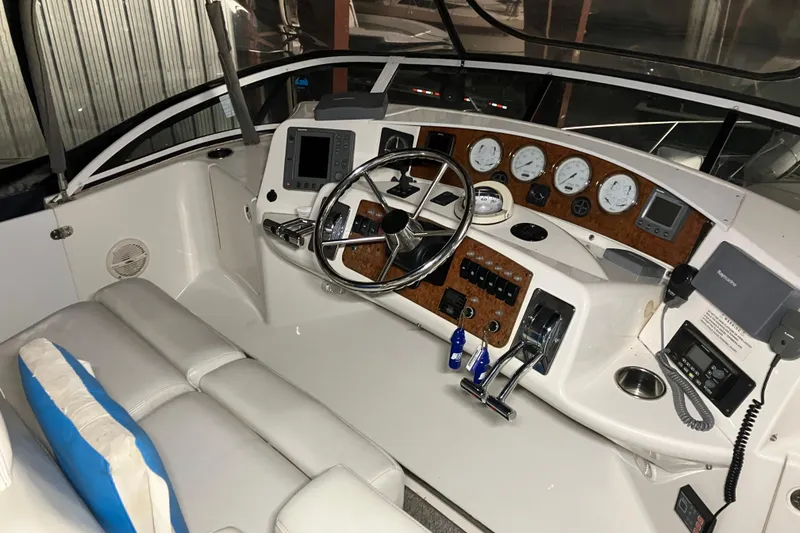 Slide: The Image of 2002 Silverton 39 Motor Yacht helm with steering wheel, gauges, and navigation equipment. - 9