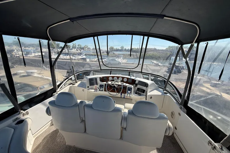 Slide: The Image of 2002 Silverton 39 Motor Yacht helm with panoramic marina view. - 6