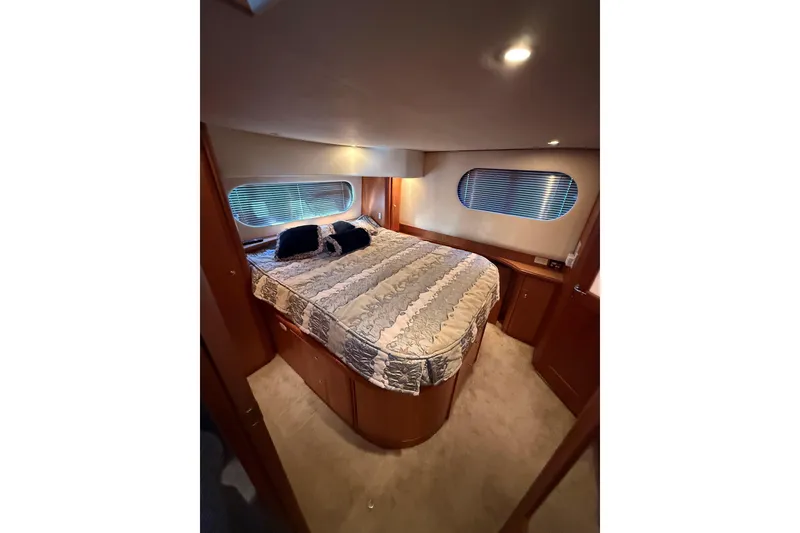 Slide: The Image of Luxurious bedroom interior of 2002 Silverton 39 Motor Yacht with cozy bedding and ambient lighting. - 33
