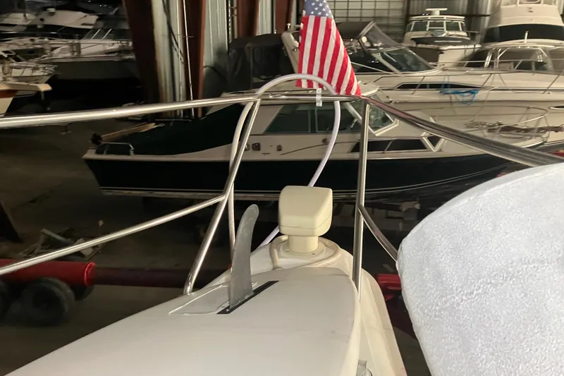 Slide: The Image of 2002 Silverton 39 Motor Yacht in storage, featuring American flag and anchor. - 59