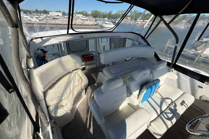 Slide: The Image of Interior of 2002 Silverton 39 Motor Yacht with white seating and marina view. - 5