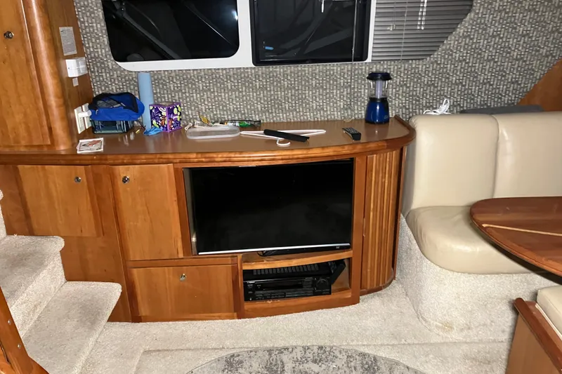 Slide: The Image of 2002 Silverton 39 Motor Yacht interior with TV, wooden cabinetry, and beige seating. - 22