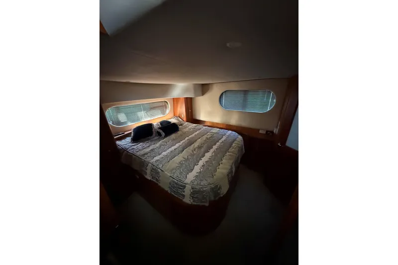 Slide: The Image of Luxurious bedroom interior of 2002 Silverton 39 Motor Yacht with cozy bedding and windows. - 34