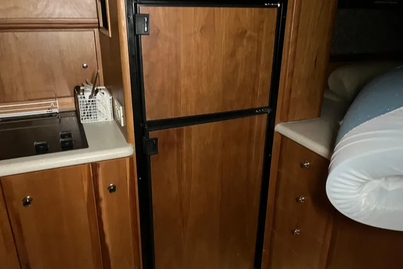 Slide: The Image of Interior of 2002 Silverton 39 Motor Yacht with wooden cabinetry and compact kitchen area. - 20