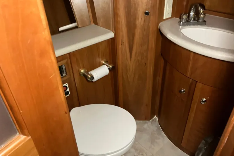 Slide: The Image of Bathroom interior of 2002 Silverton 39 Motor Yacht with wooden cabinetry and sink. - 39
