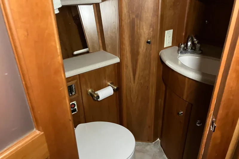 Slide: The Image of 2002 Silverton 39 Motor Yacht bathroom with wooden cabinetry and compact sink. - 40
