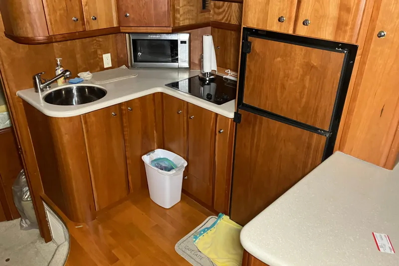 Slide: The Image of 2002 Silverton 39 Motor Yacht kitchen with wood cabinets, sink, stove, and refrigerator. - 19