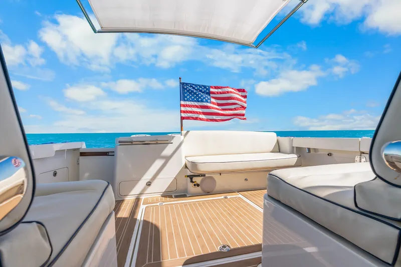 Slide: The Image of Hinckley Sport Boat 40 X 2021, luxury deck view with American flag, ocean backdrop. - 28