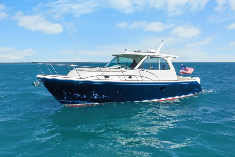 Slide: The Image of 2021 Hinckley Sport Boat 40 X cruising on open water under a clear sky. - 7