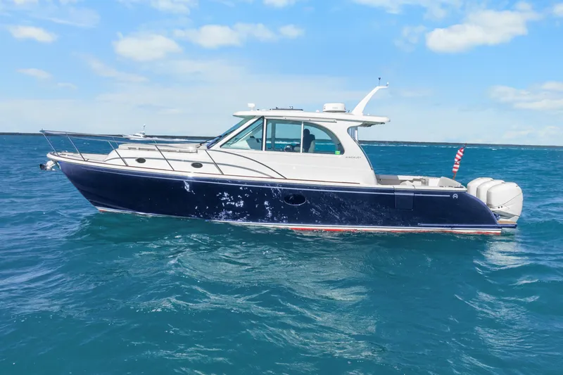 Slide: The Image of 2021 Hinckley Sport Boat 40 X cruising on open water under a clear blue sky. - 8