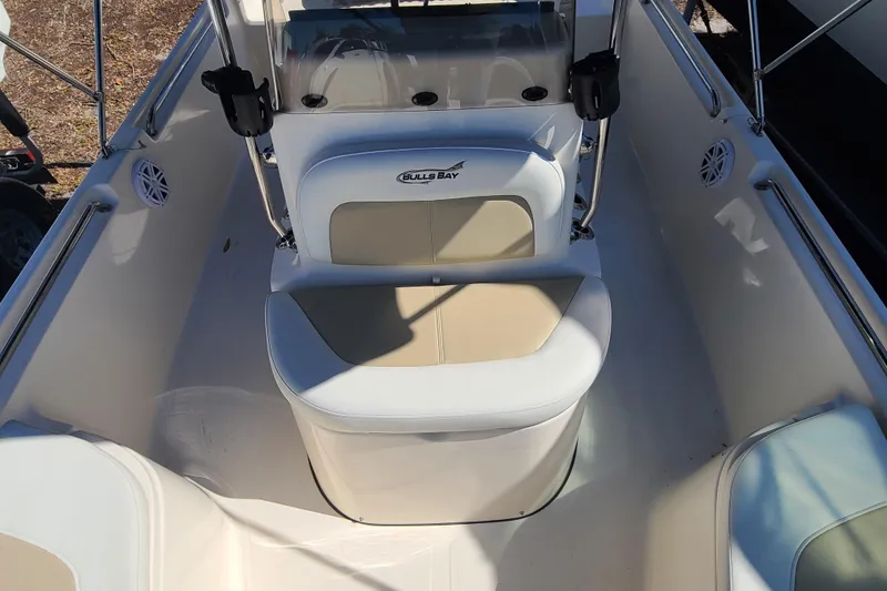 Slide: The Image of 2023 Bulls Bay 2000 boat interior with seating and console, featuring white and beige upholstery. - 11