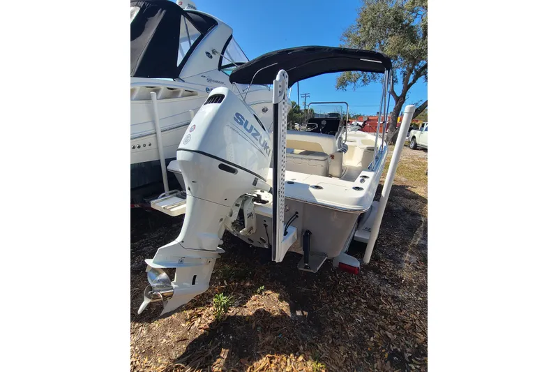 Slide: The Image of 2023 Bulls Bay 2000 boat with Suzuki outboard motor, parked outdoors. - 2