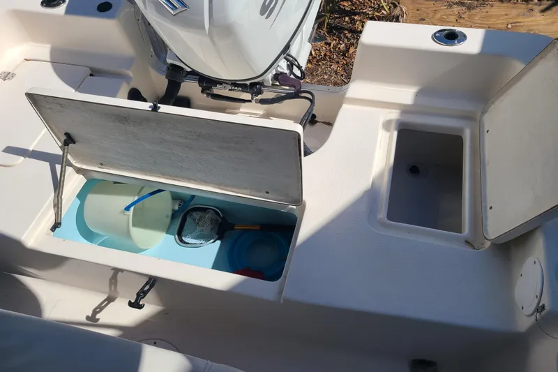 Slide: The Image of 2023 Bulls Bay 2000 boat interior with open storage compartments and fishing gear. - 21