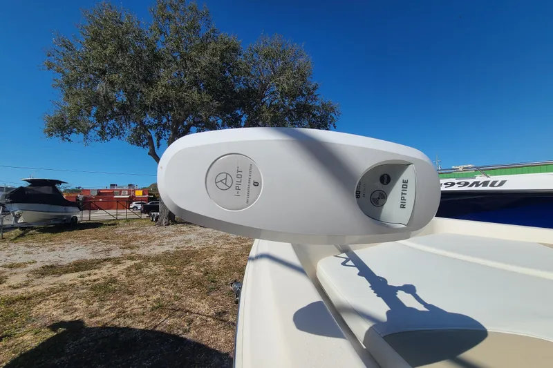 Slide: The Image of Bulls Bay 2000 boat with i-Pilot Riptide motor, 2023 model, under clear blue sky. - 7