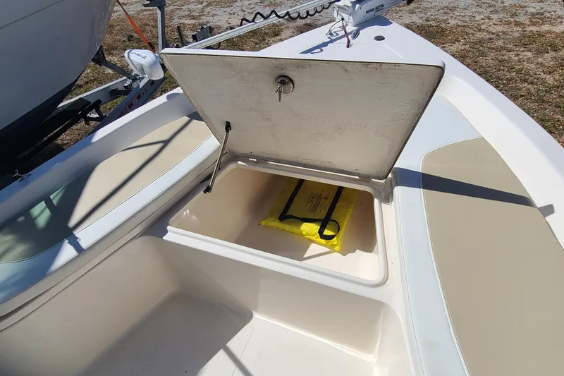 Slide: The Image of Open storage compartment on 2023 Bulls Bay 2000 boat, featuring a yellow safety bag. - 8