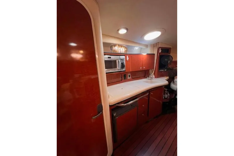 Slide: The Image of Interior of 2005 Sea Ray Sundancer 320 yacht, featuring a compact kitchen area. - 4