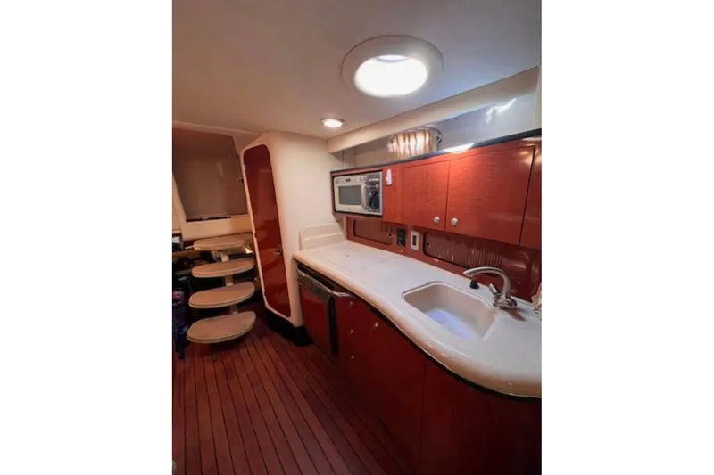 Slide: The Image of 2005 Sea Ray Sundancer 320 interior kitchen with wooden cabinets and modern appliances. - 5