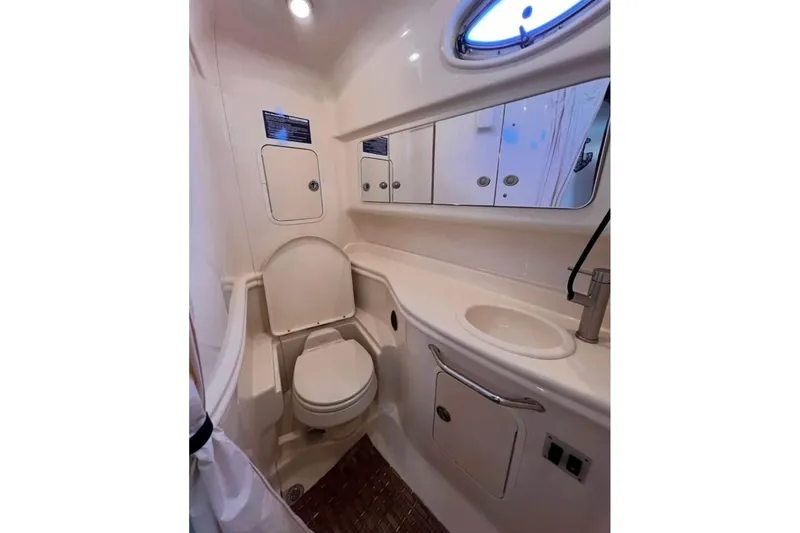 Slide: The Image of 2005 Sea Ray Sundancer 320 bathroom with toilet, sink, and storage cabinets. - 8