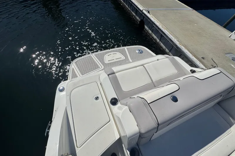 Slide: The Image of 2011 Sea Ray 260 Bow Rider boat docked, showing rear seating and swim platform. - 10