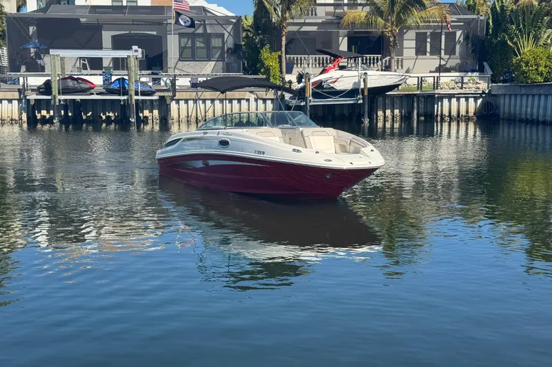 Slide: The Image of 2011 Sea Ray 260 Bow Rider boat on calm water near a docked house. - 3