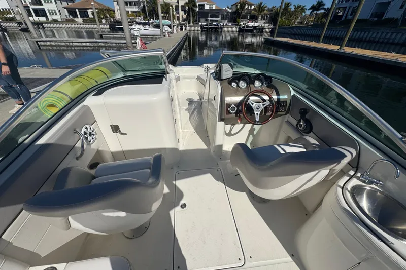 Slide: The Image of 2011 Sea Ray 260 Bow Rider interior with helm, seating, and dockside view. - 5