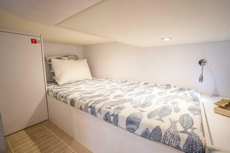 Slide: The Image of Cozy cabin bed in 2016 VanDutch 55 yacht with patterned bedding and reading light. - 18