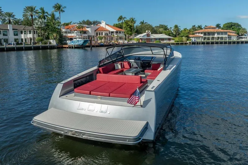 Slide: The Image of Luxury 2016 VanDutch 55 yacht with red seating, docked near waterfront homes. - 4