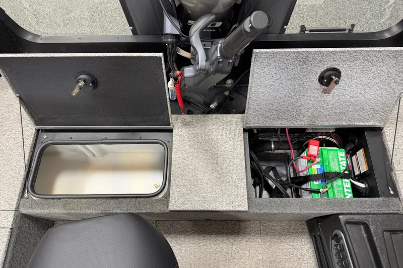 Slide: The Image of 2023 Alumacraft Competitor 185 Tiller interior showing storage compartments and battery setup. - 15
