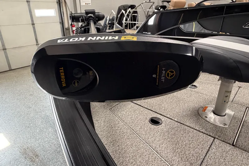 Slide: The Image of 2023 Alumacraft Competitor 185 Tiller with Minn Kota Terrova motor in a garage setting. - 19