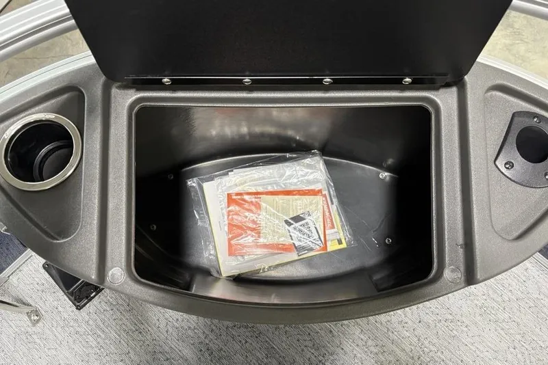 Slide: The Image of Storage compartment of 2026 Sun Tracker BASS BUGGY® 18 DLX with cup holders and manuals. - 13