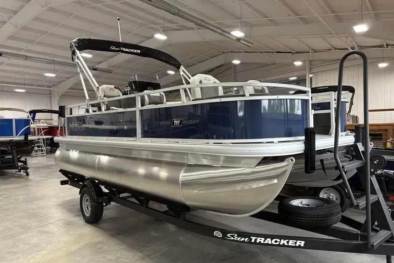 Slide: The Image of 2026 Sun Tracker BASS BUGGY® 18 DLX pontoon boat on trailer in showroom. - 5