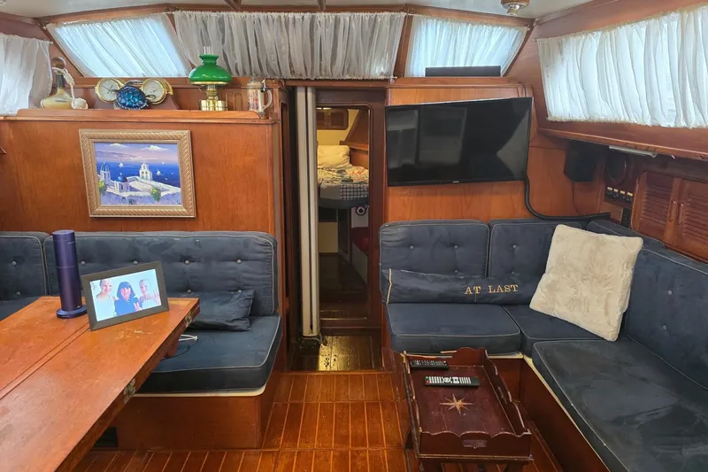Slide: The Image of Interior of 1982 Irwin 52 yacht with cozy seating, decor, and wood paneling. - 13