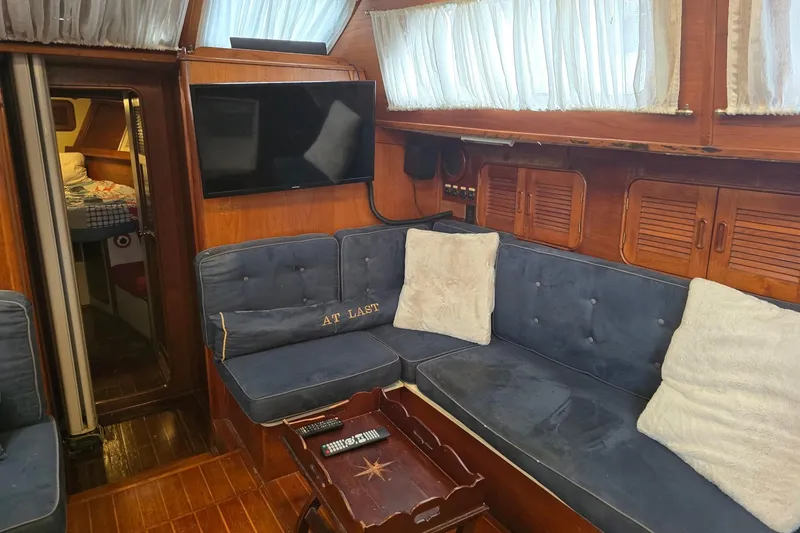 Slide: The Image of Cozy interior of 1982 Irwin 52 yacht with blue seating and wooden accents. - 14