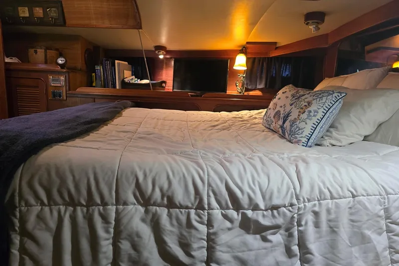 Slide: The Image of Cozy cabin bedroom in a 1982 Irwin 52 sailboat with plush bedding and warm lighting. - 17