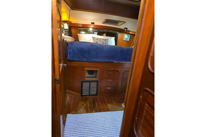 Slide: The Image of Cozy cabin interior of 1982 Irwin 52 sailboat with wooden furnishings and blue bedding. - 22