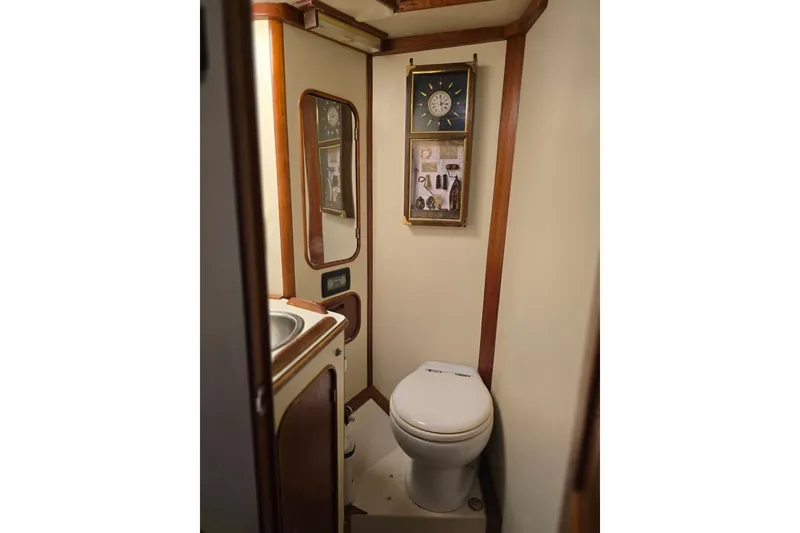 Slide: The Image of Compact bathroom in a 1982 Irwin 52 yacht, featuring a toilet, sink, and nautical decor. - 24