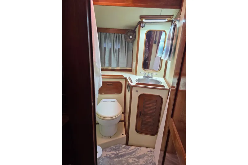 Slide: The Image of 1982 Irwin 52 yacht bathroom with sink, toilet, and mirror. - 28