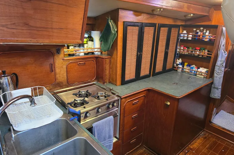 Slide: The Image of 1982 Irwin 52 yacht kitchen with stove, sink, and wooden cabinetry. - 8